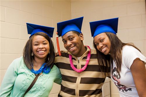 Three students wearing graduation caps 